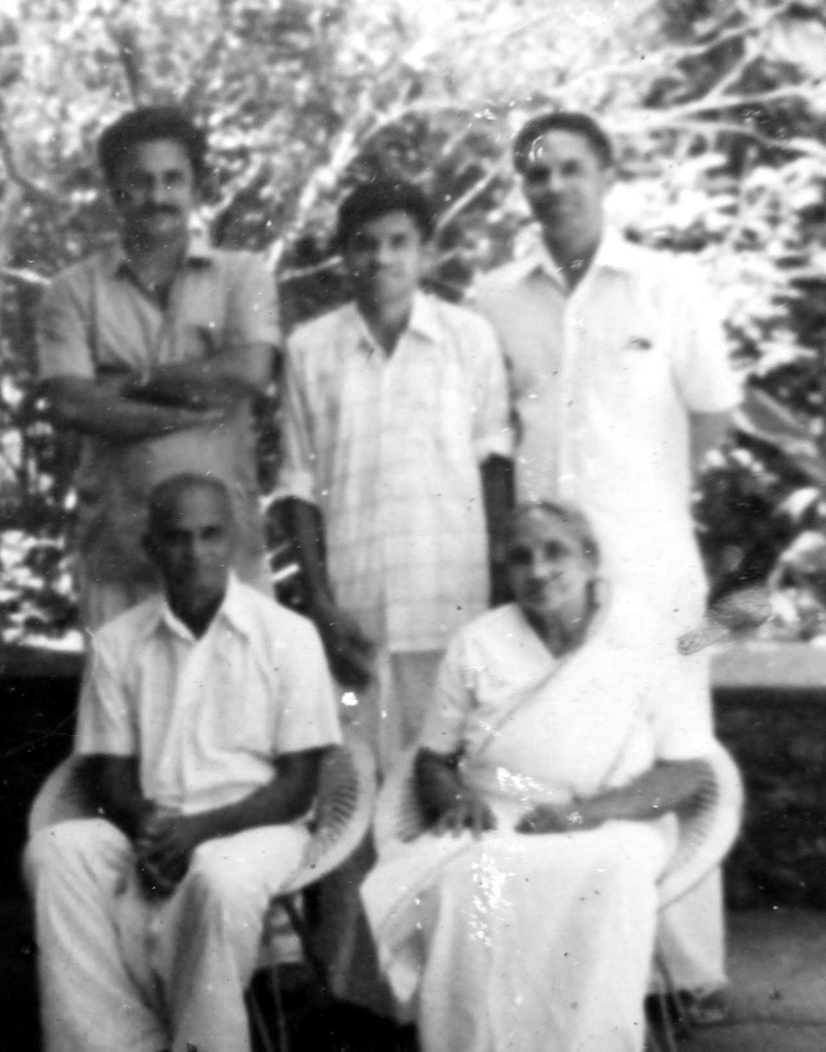 Kuriachan and Raheal seated on the verandah, their three sons standing behind them