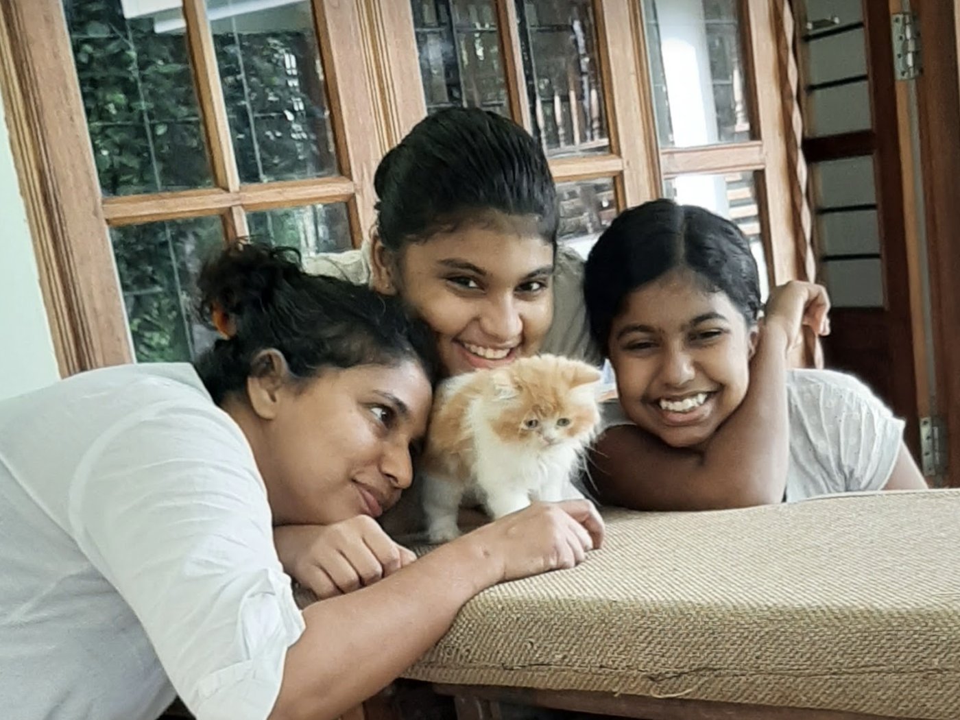Sandhya, Mariya and Rebecca with Luca as a kitten, on the verandah sofa